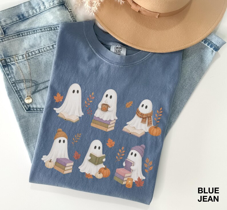 Blue Jean Comfort Colors shirt featuring six cozy reading ghosts with books, pumpkins, autumn leaves, scarves, hats, and seasonal book lover details.