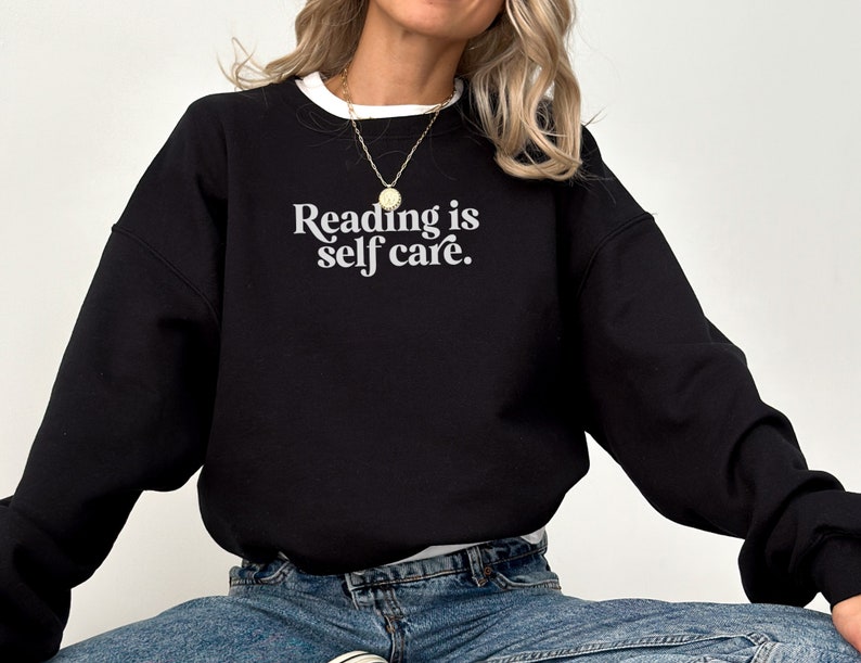 May include: Black sweatshirt with the text "Reading is self care." in white lettering.