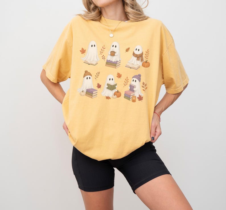 Mustard Comfort Colors shirt featuring six adorable Halloween reading ghosts with books, pumpkins, autumn leaves, cozy hats, scarves, and warm fall details.