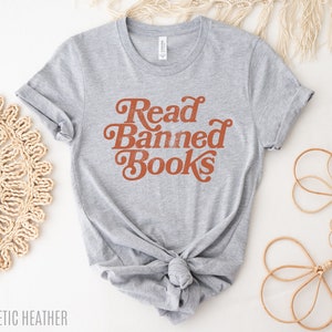 May include: A gray t-shirt with the text "Read Banned Books" in orange lettering. The shirt is tied in a knot at the bottom.