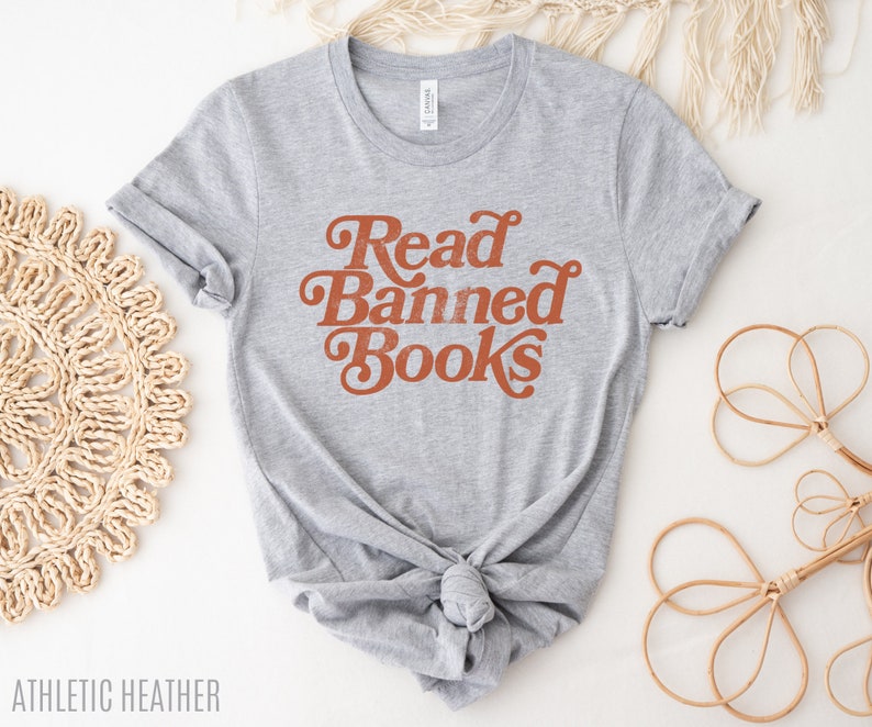 May include: A gray t-shirt with the text "Read Banned Books" in orange lettering. The shirt is tied in a knot at the bottom.