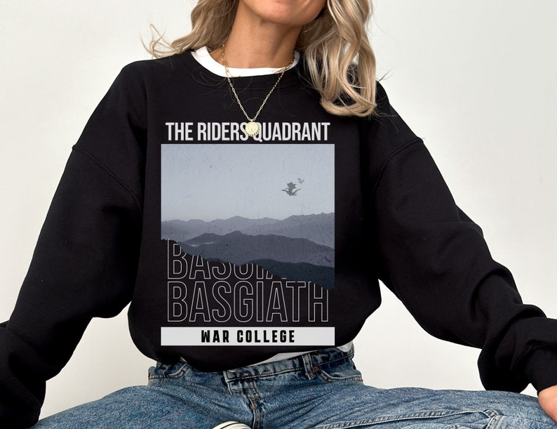 Puede incluir: Sudadera negra con un estampado gr&aacute;fico de una cordillera y el texto "The Riders Quadrant Basquiath War College".