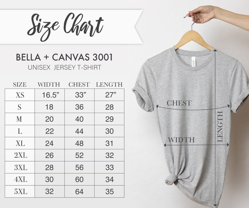 Puede incluir: Una camiseta unisex Bella + Canvas 3001 gris claro colgada de una percha de madera. La imagen incluye una tabla de tallas con medidas en cm para ancho, pecho y largo, desde XS hasta 5XL.