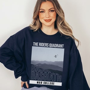 Puede incluir: Sudadera azul marino con un estampado gr&aacute;fico de una cordillera y el texto "The Riders Quadrant" y "War College".