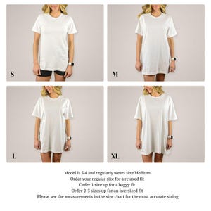 May include: A white t-shirt in four different sizes: S, M, L, and XL. The model is 5'4 and wears a size Medium. The text on the image reads: "Model is 5'4 and regularly wears size Medium. Order your regular size for a relaxed fit. Order 1 size up for a baggy fit. Order 2-3 sizes up for an oversized fit. Please see the measurements in the size chart for the most accurate sizing."