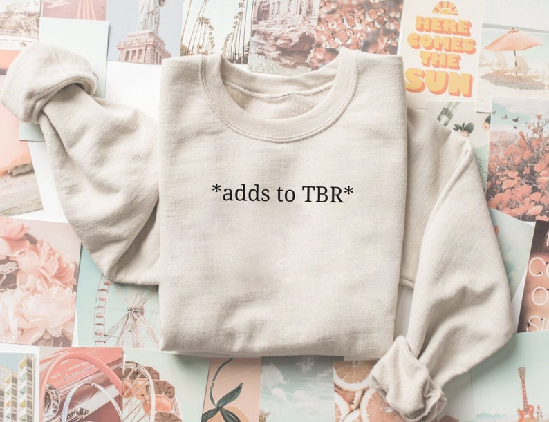May include: A beige sweatshirt with the text "*adds to TBR*" printed on the front.