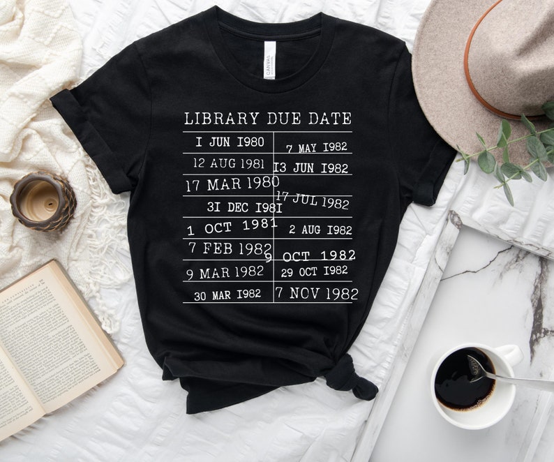 May include: Black t-shirt with white text that reads "LIBRARY DUE DATE" and lists dates from June 1980 to November 1982.