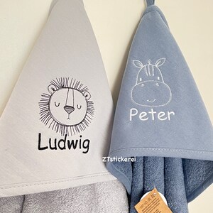 May include: Two hooded towels, one gray with a lion and the name "Ludwig" embroidered on it, and one blue with a zebra and the name "Peter" embroidered on it.