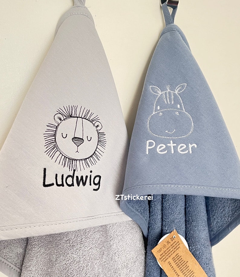 May include: Two hooded towels, one gray with a lion and the name "Ludwig" embroidered on it, and one blue with a zebra and the name "Peter" embroidered on it.