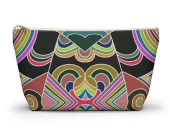 May include: A zipped pouch with a vibrant geometric design. The pattern includes a black backdrop with symmetrical shapes in pink, green, blue, and brown. The zip is gold-coloured.