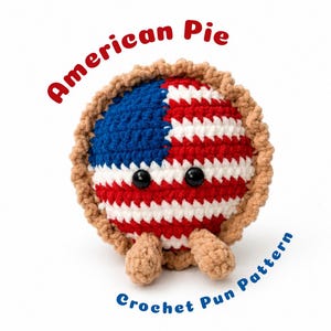 Può includere: Un peluche rotondo lavorato all'uncinetto a forma di torta, con un bordo color crosta e una superficie superiore con il motivo della bandiera americana in rosso, bianco e blu. Ha due occhi a perla neri e piccoli piedi beige. Testo: American Pie Crochet Pun Pattern.