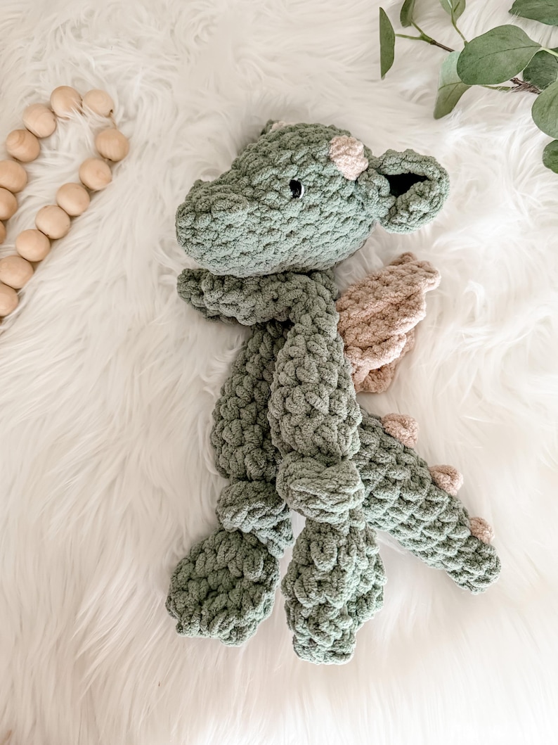 Peut inclure: Un dragon en crochet fait &agrave; la main, vert et beige. Le dragon a un aspect textur&eacute; et &eacute;pais, avec des ailes d&eacute;taill&eacute;es et de petits yeux ronds. Le jouet en peluche est con&ccedil;u pour &ecirc;tre doux et c&acirc;lin.