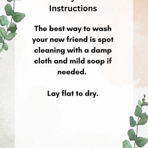 May include: A white card with black text outlining care instructions for a lovey. The text reads "Lovey Care Instructions. The best way to wash your new friend is spot cleaning with a damp cloth and mild soap if needed. Lay flat to dry."