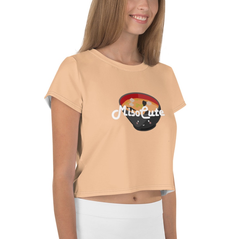 May include: A peach colored women's crop top with short sleeves featuring a black bowl of miso soup with a cute face and the text "MisoCute" in white.