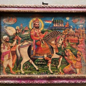 May include: A framed religious print depicting a figure on horseback, surrounded by other figures and architectural elements. The artwork features vibrant colors, including reds, blues, and yellows, and is set within a decorative, ornate frame.