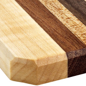 Peut inclure: Gros plan sur une planche &agrave; d&eacute;couper en bois avec un motif de grain de bois brun clair, brun fonc&eacute; et clair. La planche a un bord biseaut&eacute;.