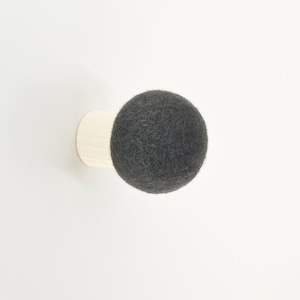 May include: A gray felt ball attached to a wooden base, a wall-mounted hook.