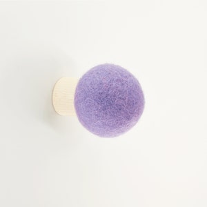 May include: A purple felt ball attached to a wooden base, a decorative wall hook.