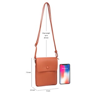 Puede incluir: Un bolso bandolera de piel sint&eacute;tica marr&oacute;n con un cierre de bot&oacute;n &uacute;nico. El bolso mide 15,2 cm de ancho, 19 cm de alto y tiene una correa ajustable de 66 cm. El bolso se muestra con un iPhone 12 para comparar el tama&ntilde;o.