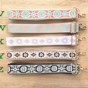 Pu&ograve; includere: Cinque tracolle regolabili etichettate da V a Z, ognuna con un motivo intrecciato unico. La tracolla V &egrave; arancione e blu, W beige e blu, X viola, Y nera e beige, e Z nera e bianca. Tutte includono componenti in metallo color oro.