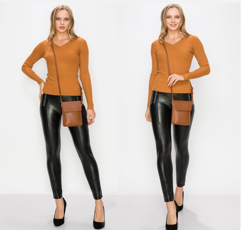 Puede incluir: Una mujer lleva un su&eacute;ter de punto marr&oacute;n y leggings de cuero negro. Lleva un bolso de cuero marr&oacute;n cruzado con cierre de solapa.