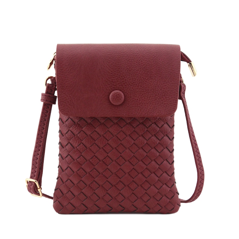 May include: A burgundy faux leather crossbody bag with a woven front panel and a flap closure with a gold button.