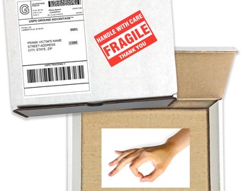 May include: A cardboard box with a white label that says "USPS GROUND ADVANTAGE" and a red "HANDLE WITH CARE FRAGILE THANK YOU" sticker. The box is open and a hand is making the "OK" sign inside.