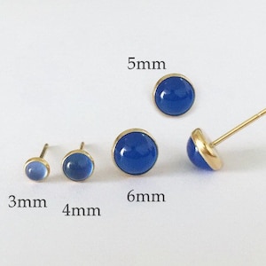 Op de afbeelding: Vier paar blauwe edelsteen oorbellen met gouden instellingen. De oorbellen worden getoond in verschillende maten: 3 mm, 4 mm, 5 mm en 6 mm.