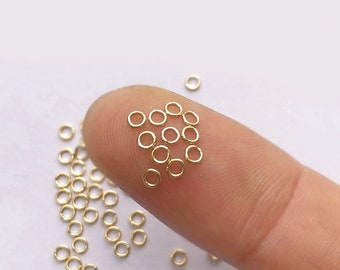 May include: A close-up of a pile of small, gold jump rings. The rings are about 5mm in diameter and are perfect for jewelry making.