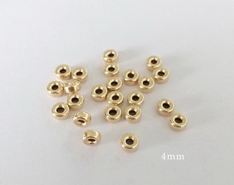 May include: A group of 20 gold-colored metal spacer beads, each measuring 4 mm in diameter. The beads are scattered on a white surface.