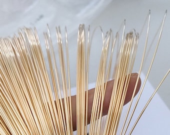 May include: A close-up of a bundle of gold-coloured wire. The wire is thin and appears to be made of metal.