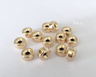 May include: A group of 12 gold-colored metal beads, each measuring 8 mm in diameter. The beads are round with a hole in the center and a raised lip around the edge.