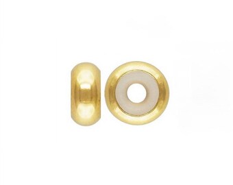 May include: Two gold-toned bead spacers with a white center. The spacers are round and have a hole in the center.