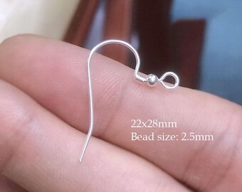 Puede incluir: Primer plano de un gancho de pendiente plateado. El gancho mide 28 mm de largo y 22 mm de ancho, con una cuenta de 2,5 mm. El gancho de pendiente está diseñado para la fabricación de joyas.