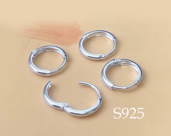 May include: Four silver hoop earrings with a hinged closure. The earrings are all different sizes. The largest earring is about 1 inch in diameter. The smallest earring is about 1/2 inch in diameter. The earrings are all made of sterling silver.