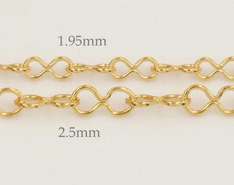 May include: Close-up of two gold-coloured chain necklaces. The top chain is labelled 1.95mm, and the bottom chain is labelled 2.5mm. The chains have an infinity-shaped link design. The background is a light, neutral colour.