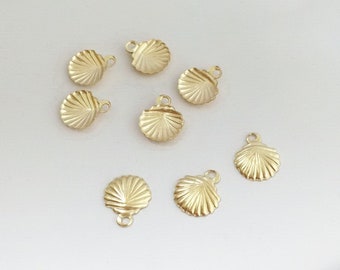 May include: Eight gold-colored metal seashell charms with a textured surface. The charms have a loop at the top for attaching to jewelry or other crafts.