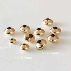 Puede incluir: Surtido de tapones de cuentas de metal de color dorado en varios tamaños. Los tapones de cuentas son redondos con una parte superior plana y un agujero en el centro. Los tamaños están etiquetados como 3,6x2 mm, 4,5x2,5 mm y 5,5x3,3 mm.