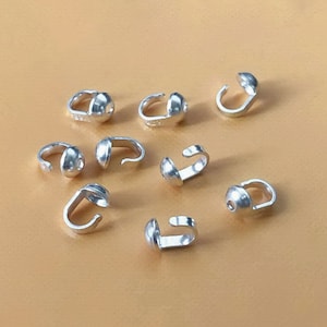 May include: Silver-toned metal bead caps with a loop on each side. The bead caps are designed to be used for jewellery making.