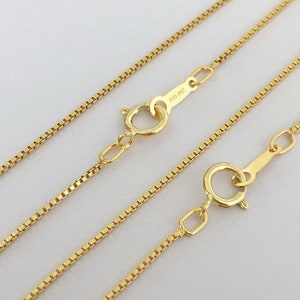 Può includere: Una collana a catena d'oro con uno stile a catena box. La catena ha due chiusure, una con l'iscrizione "100/14KT".