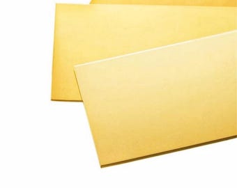 May include: Three sheets of golden-yellow paper are layered diagonally against a white background. The paper has a smooth, matte finish. The top sheet is slightly darker than the other two, creating a subtle contrast. The image is well-lit, highlighting the paper's texture.