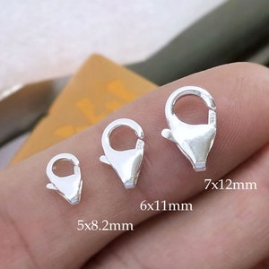 May include: Three silver lobster claw clasps of different sizes. The smallest clasp measures 5x8.2mm, the middle clasp measures 6x11mm, and the largest clasp measures 7x12mm.