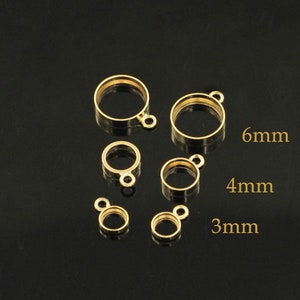 May include: Five gold-colored metal bezel settings with jump rings. The bezels are 3mm, 3mm, 4mm, 4mm, and 6mm in diameter.