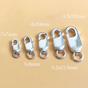 以下が含まれることがあります： 異なるサイズのシルバーロブスタークラスプが5つ。クラスプは小さい順に並んでいます。サイズはミリメートルで表示されています: 2.7x7mm、3x8mm、4x10mm、4.5x12mm、5.2x13.5mm。