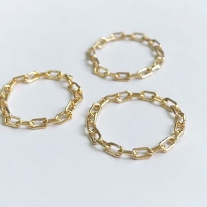 Könnte beinhalten: Drei goldene Kettenringe. Die Ringe bestehen aus einem verlinkten Kettendesign.
