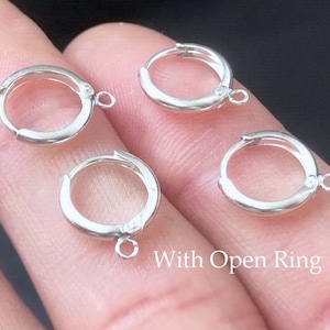 May include: Four small, silver-colored hoop earrings with open rings for attaching charms or other embellishments. The earrings are round and have a simple, classic design. The text "With Open Ring" is visible in the image.