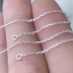 May include: Three silver chain earring components with a straight post and a loop at the end of each chain.
