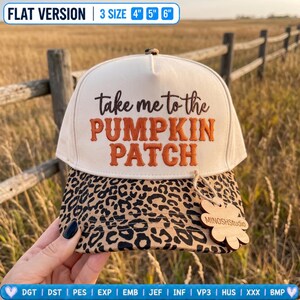 May include: A cream-coloured baseball cap with a leopard print brim. The front features embroidered text in brown and orange that reads "take me to the PUMPKIN PATCH". A small wooden flower-shaped tag labelled "MINOSHStudio" is attached to the brim.