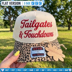 May include: A cream-colored baseball cap with a leopard print brim. The front features red embroidered text reading Tailgates & Touchdowns. A sticker on the brim reads OTTO Classic Fit Mid Profile. A flower-shaped tag reads MINOSHStudio.