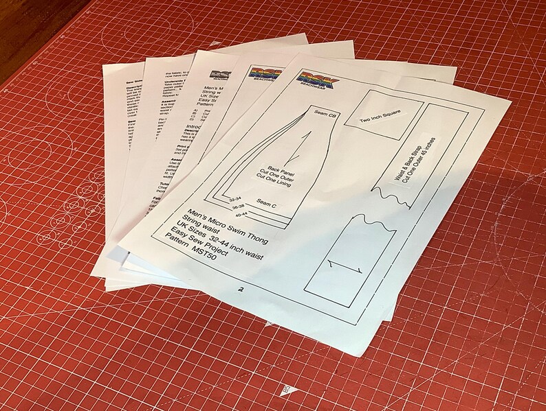 K&ouml;nnte beinhalten: Ein Stapel wei&szlig;er Papierb&ouml;gen mit einem Schnittmuster f&uuml;r einen Micro-Bade-String. Das oberste Blatt zeigt technische Strichzeichnungen, ein 5-cm-Testquadrat sowie Text, darunter Micro Swim Thong, UK-Gr&ouml;&szlig;en 32-44 und Pattern MST50.